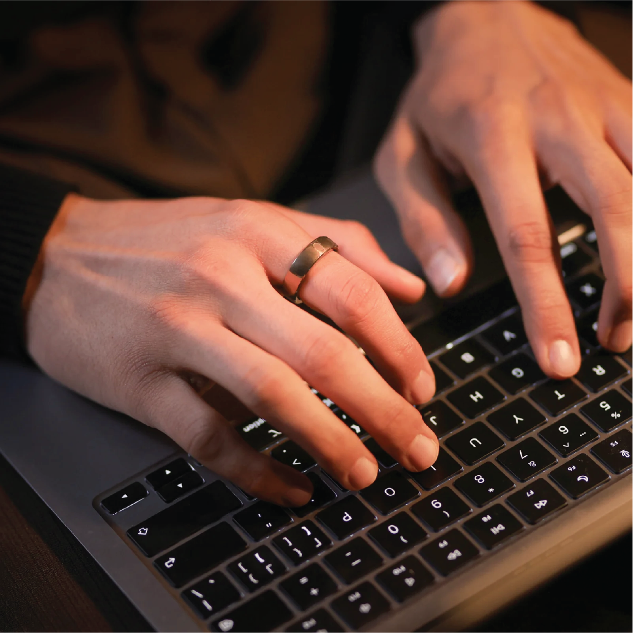 Person typing while wearing RingConn Smart RIng Gen 2 Air in Dune Gold