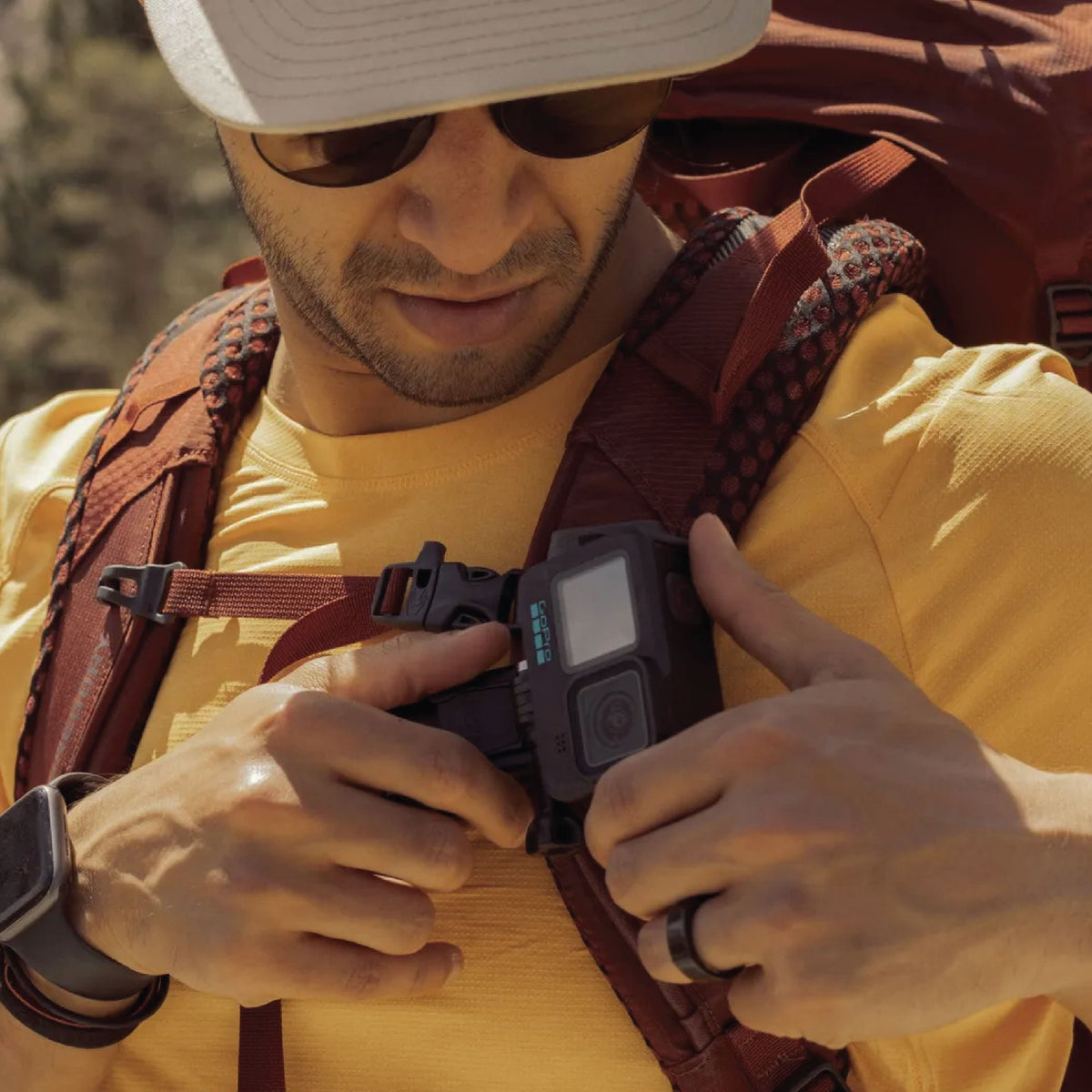 Guy clipping his GoPro on his backpack strap using the Magnetic Swivel Clip